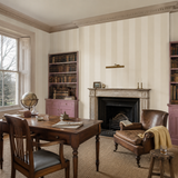 Neutral striped wallpaper in a library, Bloc Stripe Porcelain by OHPOPSI, with joinery painted in Bubble Gum