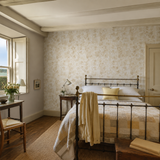 Beige floral wallpaper in a bedroom, Blossom Almond by OHPOPSI, with joinery painted in Antique Gold