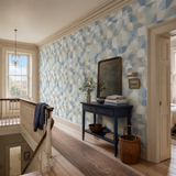 Blue geometric wallpaper in a landing, Orb - Copenhagen Blue by OHPOPSI, with joinery painted in Blueberry Tart