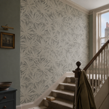 Grey botanical wallpaper in a stairwell, Palm Silhouette - Shadow by OHPOPSI, with joinery painted in Katniss