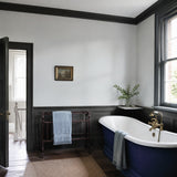 Bathroom painted in Pebbles architectural grey eco paint, with the bath panel in Blueberry Tart